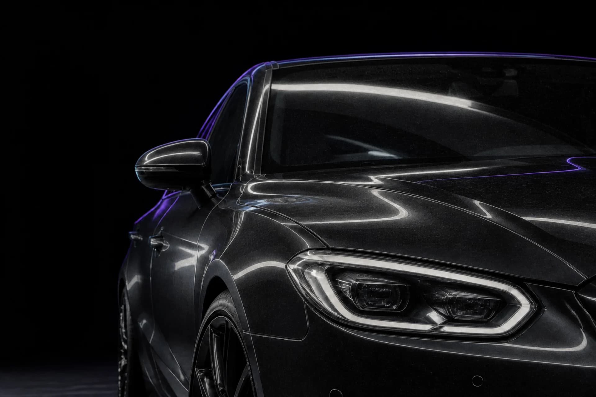 Black sedan with light road film and softened reflections