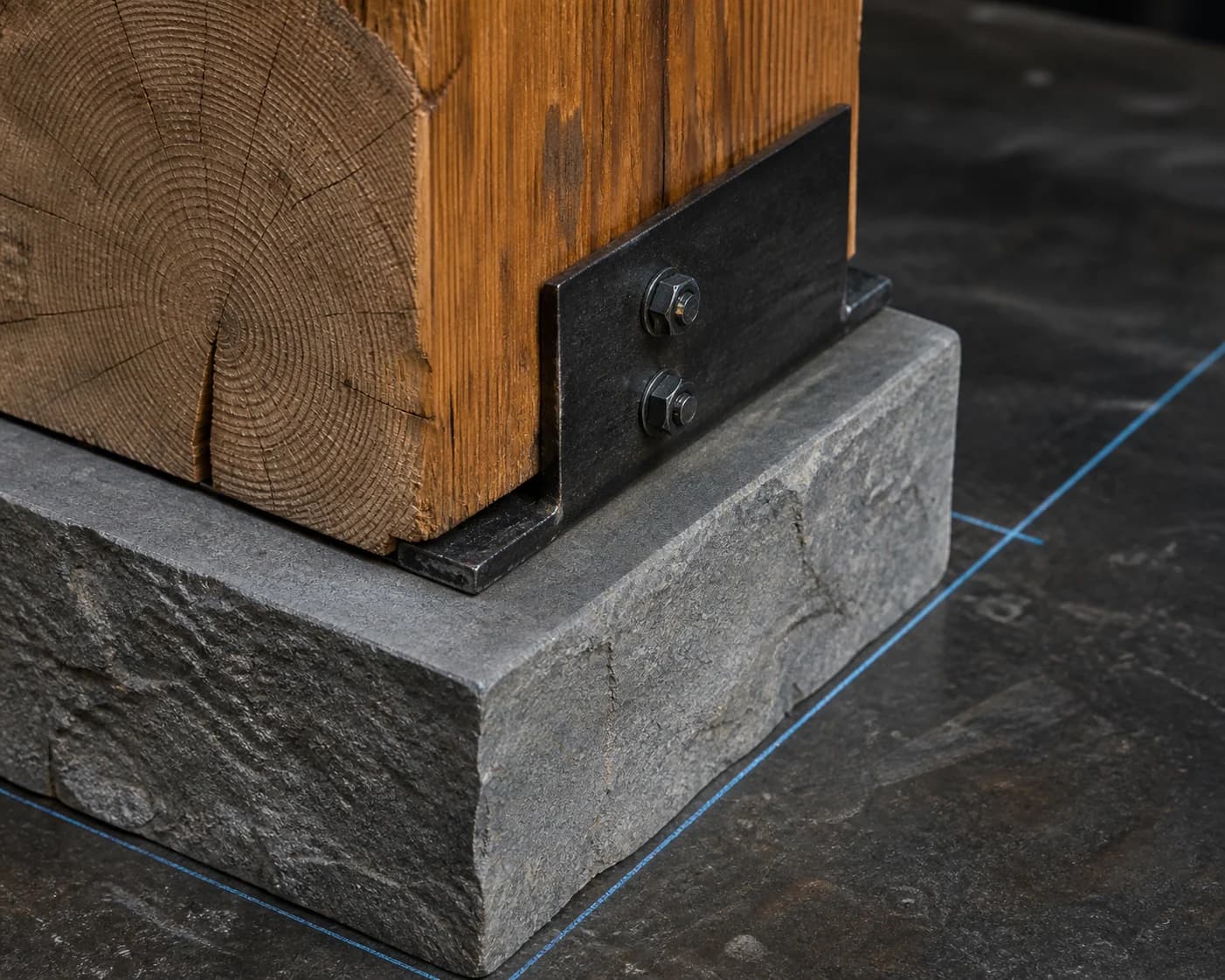 Close view of timber, stone, and blackened-steel hardware meeting