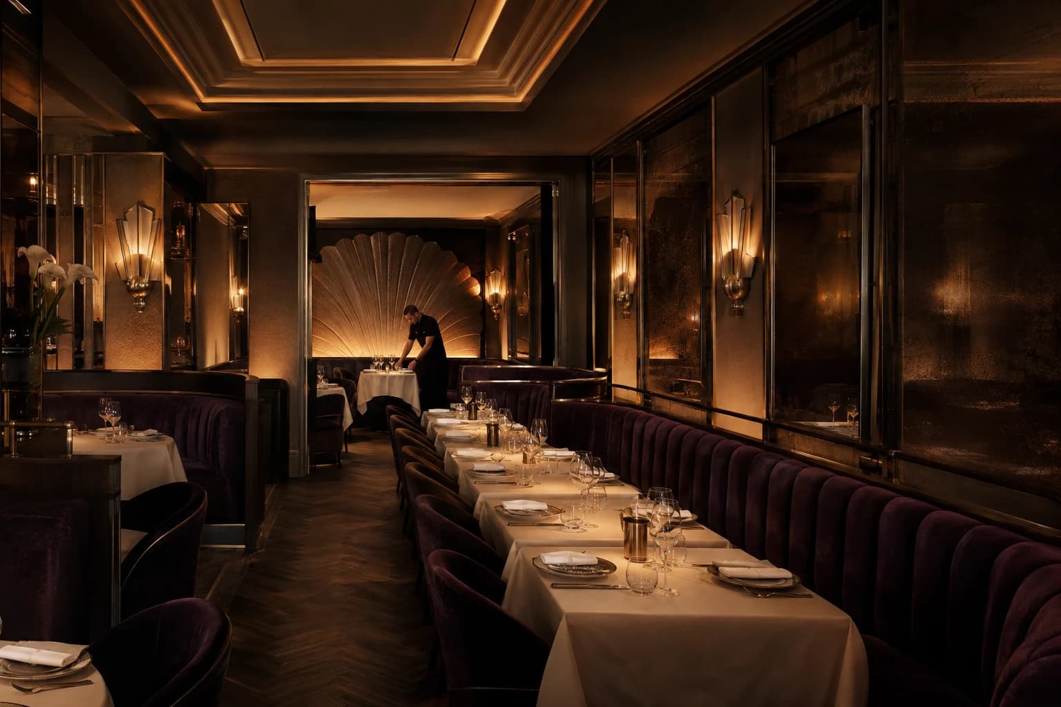 Intimate Art Deco dining room with aubergine banquettes, brass light and cream linen